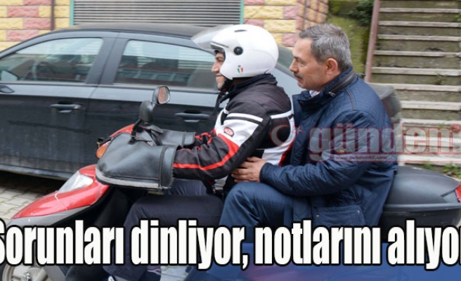 Sorunları dinliyor, notlarını alıyor